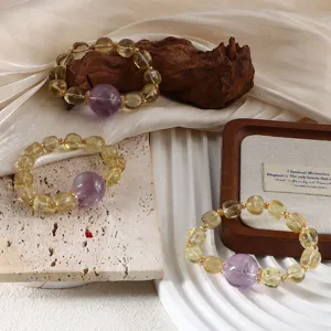 Detailed macro view of three natural citrine and amethyst beaded bracelets on elegant props