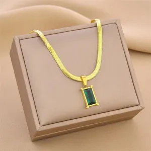 Macro view of golden titanium steel snake chain with elegant emerald green pendant