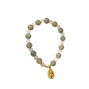 Elegant natural crystal beaded bracelet with a gold gourd charm on white background.