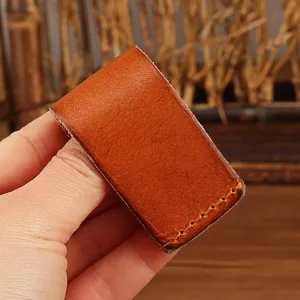 Handmade genuine leather belt key holder detail, vintage brown leather loop showcase.