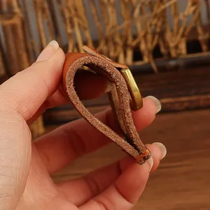 Handmade genuine leather belt key holder detail shot showing thick cowhide texture and buckle.