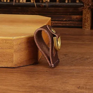 Close-up detail of genuine leather belt loop key holder with metal U-shaped buckle.