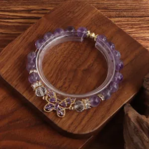 Nahaufnahme eines Natur-Amethyst-Armbands mit funkelndem Schmetterlingsanhänger