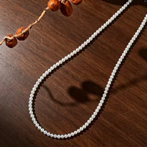 Vue macro d'un collier de perles d'eau douce naturelles avec ombre en forme de cœur.