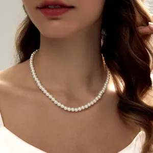 Elegante klassische weiße Kunstperlenkette an einem weiblichen Modell für einen stilvollen Look