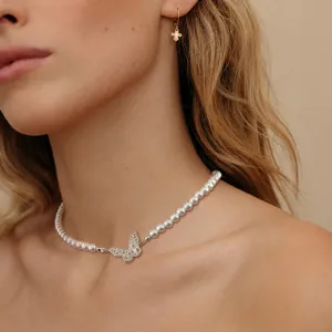 Detailansicht einer eleganten Perlenkette mit einem funkelnden Schmetterlingsanhänger.