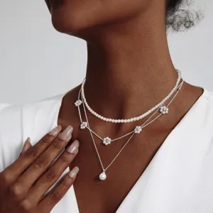 Detailansicht eines eleganten dreiteiligen Perlenhalsketten-Sets mit Blumenanhängern