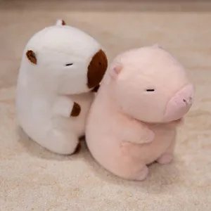 Paar zeer schattige pluche capibara-poppen in wit en roze op een zacht tapijt.