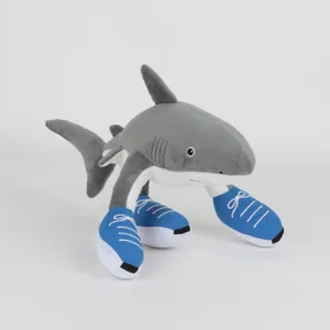 Dettaglio dello squalo di peluche Sahur con scarpe da ginnastica blu su sfondo bianco