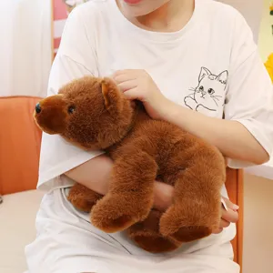 Gros plan d'une peluche d'ours brun tenue dans les bras, montrant sa fourrure réaliste.