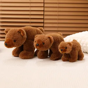 Gros plan de trois ours en peluche réalistes de différentes tailles sur un lit