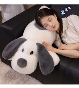 Vue rapprochée d'une peluche de chien à grandes oreilles utilisée comme oreiller de sommeil.