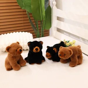 Quatre mignons ours en peluche marron et noir exposés sur un lit blanc et confortable