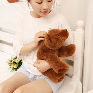 Gros plan d'une peluche d'ours brun tenue par une personne dans une chambre douillette.