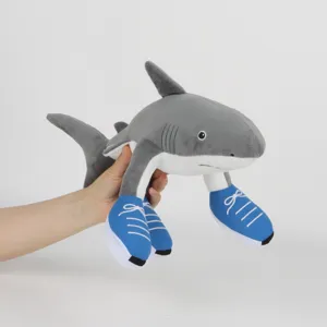 Vista dettagliata del peluche a forma di squalo Sahur con scarpe blu tenuto in mano