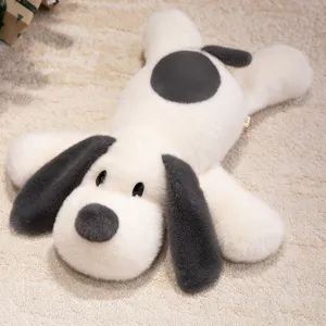 Gros plan d'une peluche de chiot aux longues oreilles sur un tapis beige
