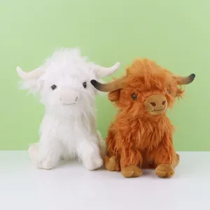 Peluches de vache Highland réalistes en blanc et marron assises sur un fond très propre