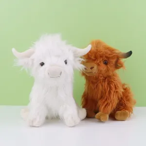 Vue détaillée de deux adorables peluches de vache Highland en blanc et marron