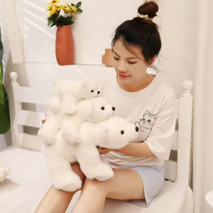 Vue détaillée de trois peluches d'ours polaires blancs tenues par un mannequin.