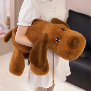Détail montrant la grande taille et la texture douce de la peluche chien marron tenue.