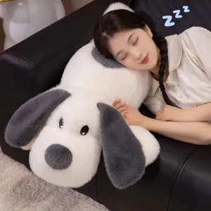Gros chien en peluche utilisé comme oreiller doux pour dormir sur un canapé