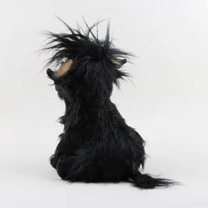 Vue détaillée d'une peluche de vache Highland noire montrant la texture des poils.