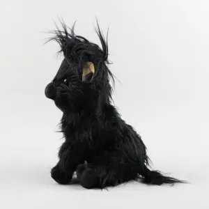 Vue latérale d'une peluche de vache Highland noire à longs poils hirsutes réalistes
