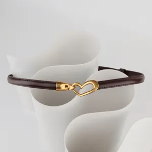 Close-up detail of dark brown leather thin belt featuring elegant gold heart buckle for dress.