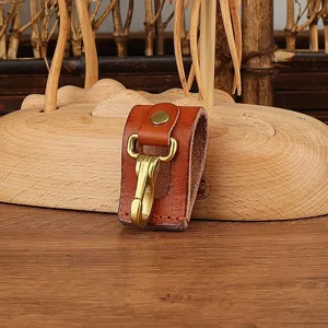 Leather belt key holder detail, durable brown leather loop with brass snap hook and metal clip.