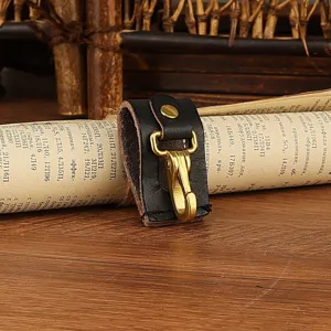 Detail shot of black leather key belt loop holder with antique brass metal hook and snap.