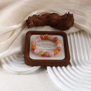 Nahaufnahme eines Naturkristall-Perlenarmbands, das auf einem Schmucktablett aus Holz liegt