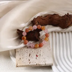 Detailansicht eines natürlichen mehrfarbigen Kristallarmbands auf Stein und Holz