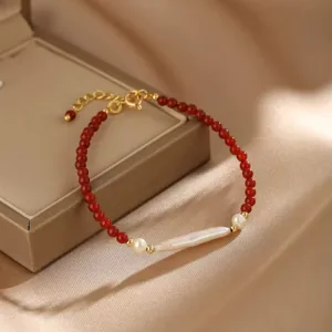 Detailaufnahme eines eleganten Armbands aus rotem Achat und Barockperlen auf Schmuck