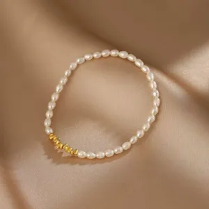 Detailansicht eines eleganten Armbands aus weißen Naturperlen mit goldenen Metallperlen