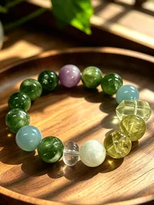 Close-up of natural green fluorite beaded bracelet on a wooden tray under sunlight.