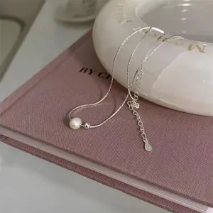 Detailansicht einer minimalistischen Süßwasserperlenkette mit einer feinen silbernen Gliederkette