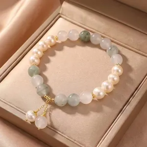 Detailed macro view of an elegant natural pearl and jadeite beaded bracelet in a gift box