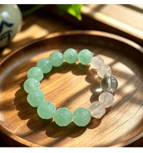Detail view of a handcrafted green fluorite and quartz beaded bracelet on a rustic wooden tray