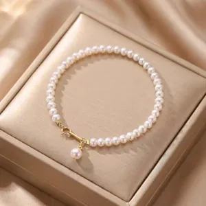 Elegant natural pearl bracelet detail featuring a lustrous pearl charm and gold clasp