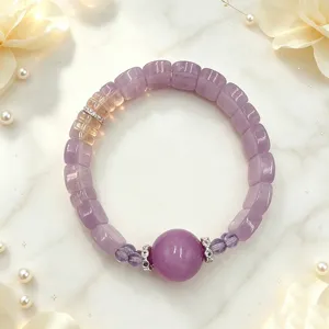 Detailansicht eines lila Kristallperlenarmbands auf weißem Marmorhintergrund