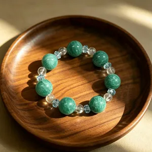 Natural green fluorite and clear crystal beaded bracelet on a dark wooden plate