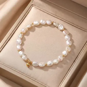 Detailed view of a natural baroque pearl bracelet with gold beads in a gift box.