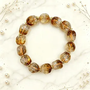 Natürliches Armband mit unregelmäßigen Kristallperlen und goldenen Elementen auf Marmor.