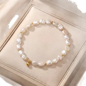 Elegant natural baroque pearl bracelet with gold bead accents in a cream jewelry box