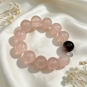 Nahaufnahme eines natürlichen Rosenquarz-Kristallperlenarmbands auf elegantem weißem Seidenstoff