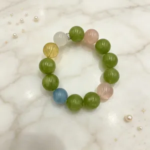 Detailansicht eines bunten Naturkristall-Perlenarmbands mit grünen und rosa Steinen