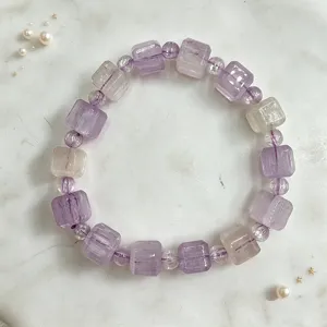 Detailansicht eines Armbands mit lila und klaren Kristallwürfeln