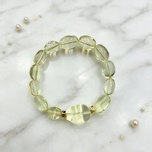 Detailansicht eines Naturquarz-Armbandes mit ovalen Perlen auf elegantem Marmorhintergrund.