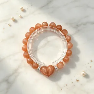 Nahaufnahme eines eleganten orangefarbenen Sonnenstein-Perlenarmbands auf Marmor