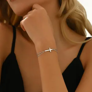 Detailansicht eines minimalistischen silbernen Doppelkettenarmbands mit einem Kreuzanhänger
